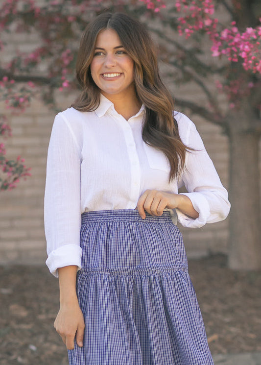 Woman wearing the Bailey crisp white cotton gauze button down top with a denim maxi skirt