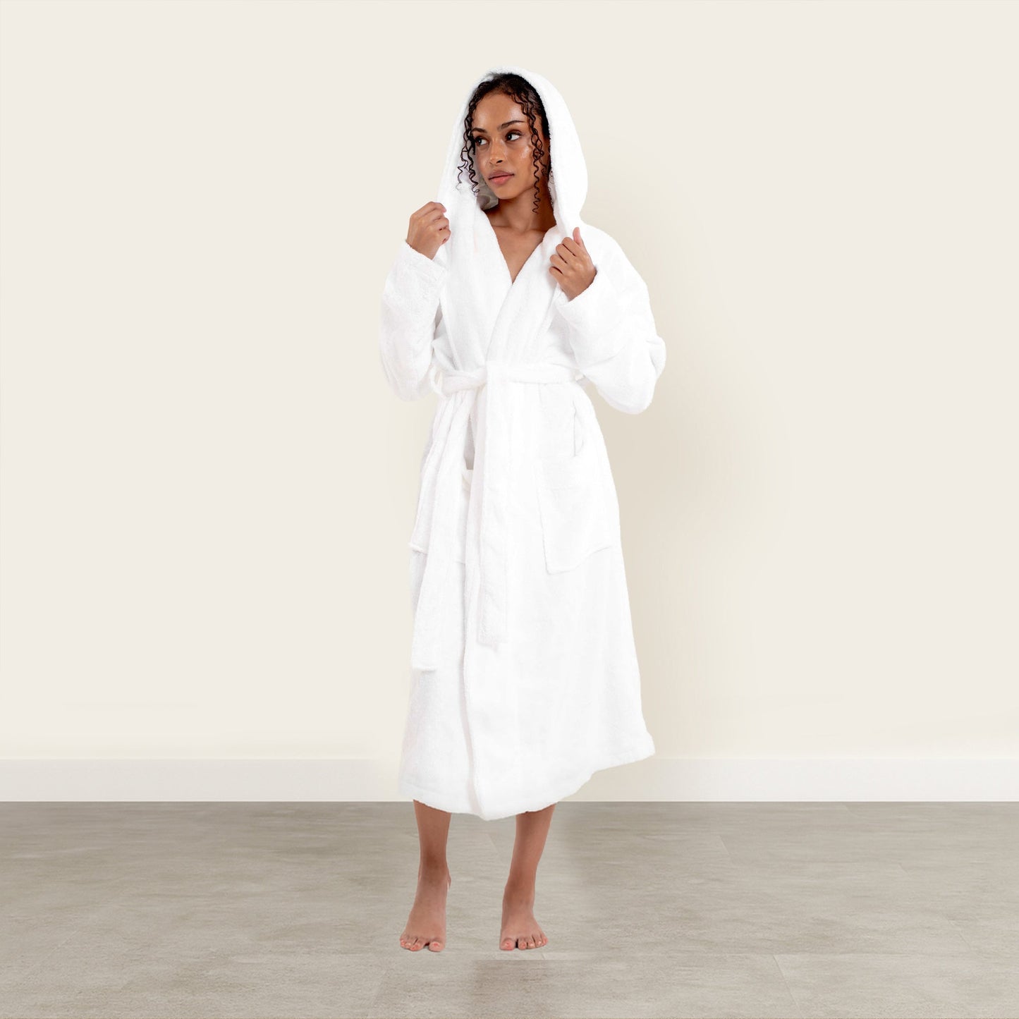 Woman wearing a white robe against a plain background