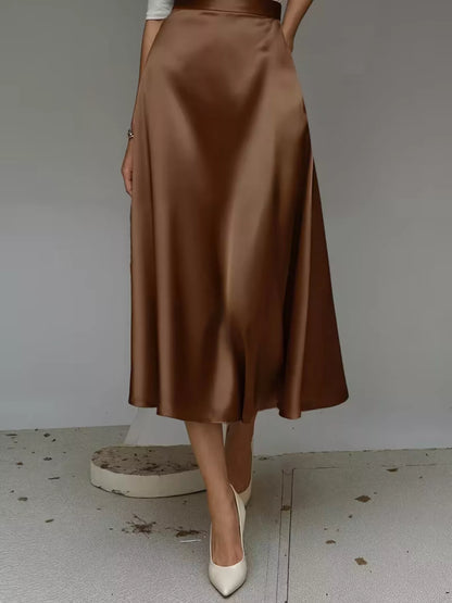 Brown satin skirt worn by a person on a plain background