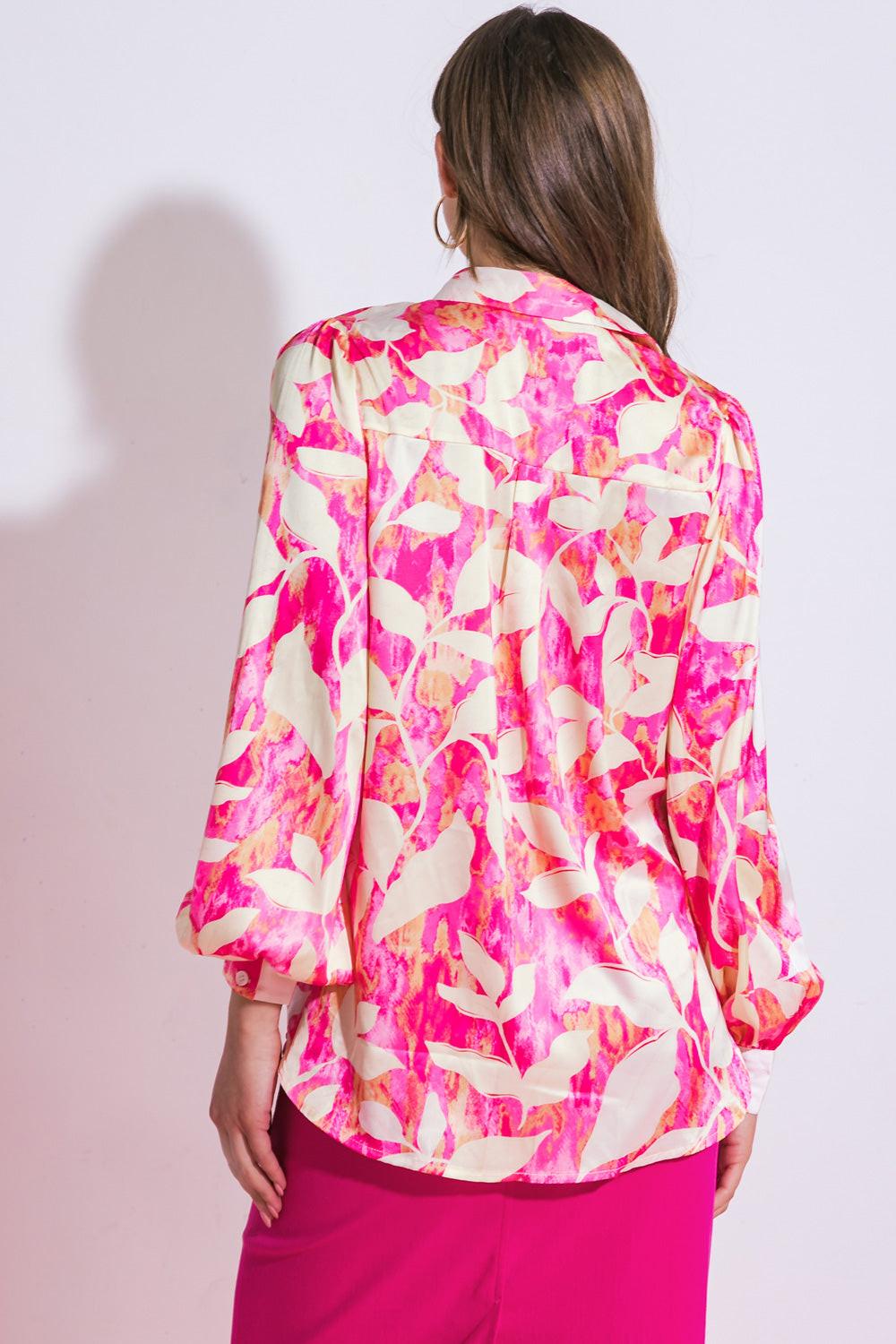 Woman wearing a colorful floral blouse with a plain background