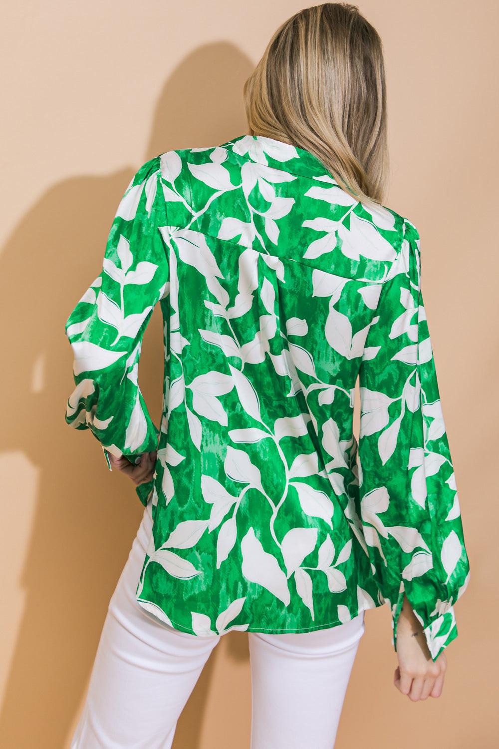 Person wearing a green and white floral blouse against a beige background