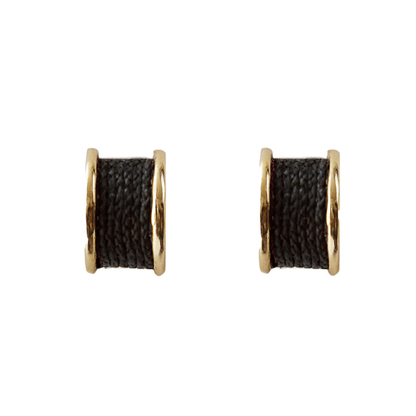 Pair of earrings with gold loops and black fabric-like centers on a white background