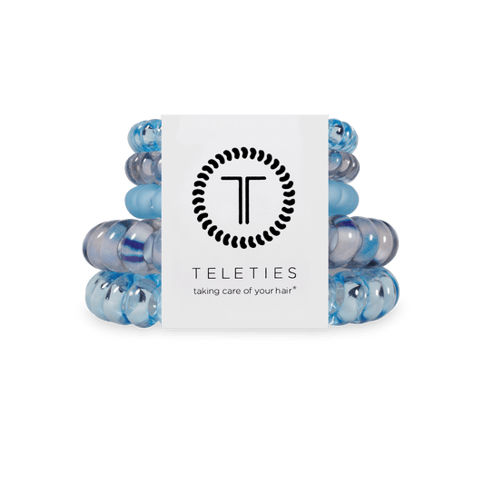 Stack of blue hair ties with a Teleties branded card on a transparent background