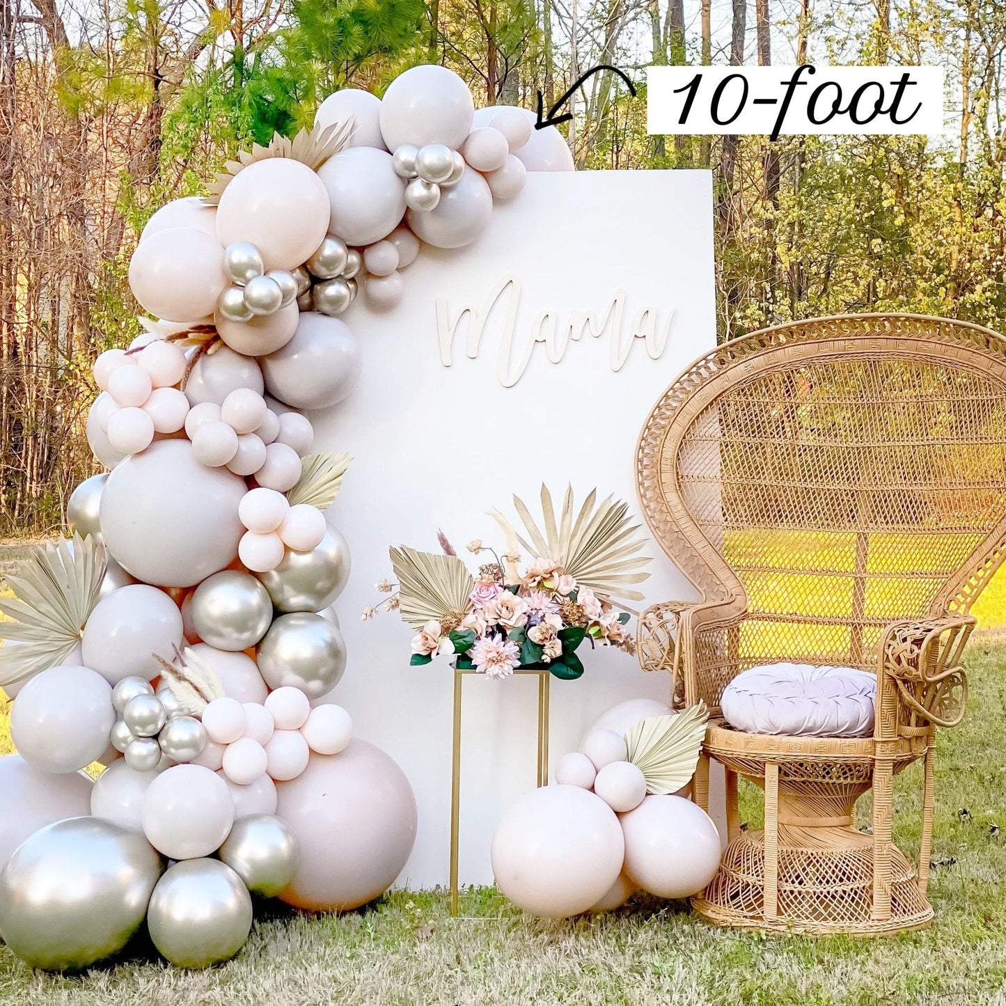 Balloon arch with '10-foot' text, wicker chair, and floral arrangement outdoors.