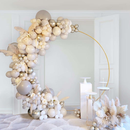 Decorative balloon arch with candles and flowers in a room setting