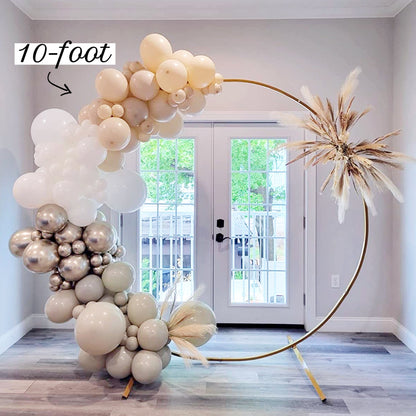 10-foot balloon arch with white and gold balloons in a room with a door in the background.
