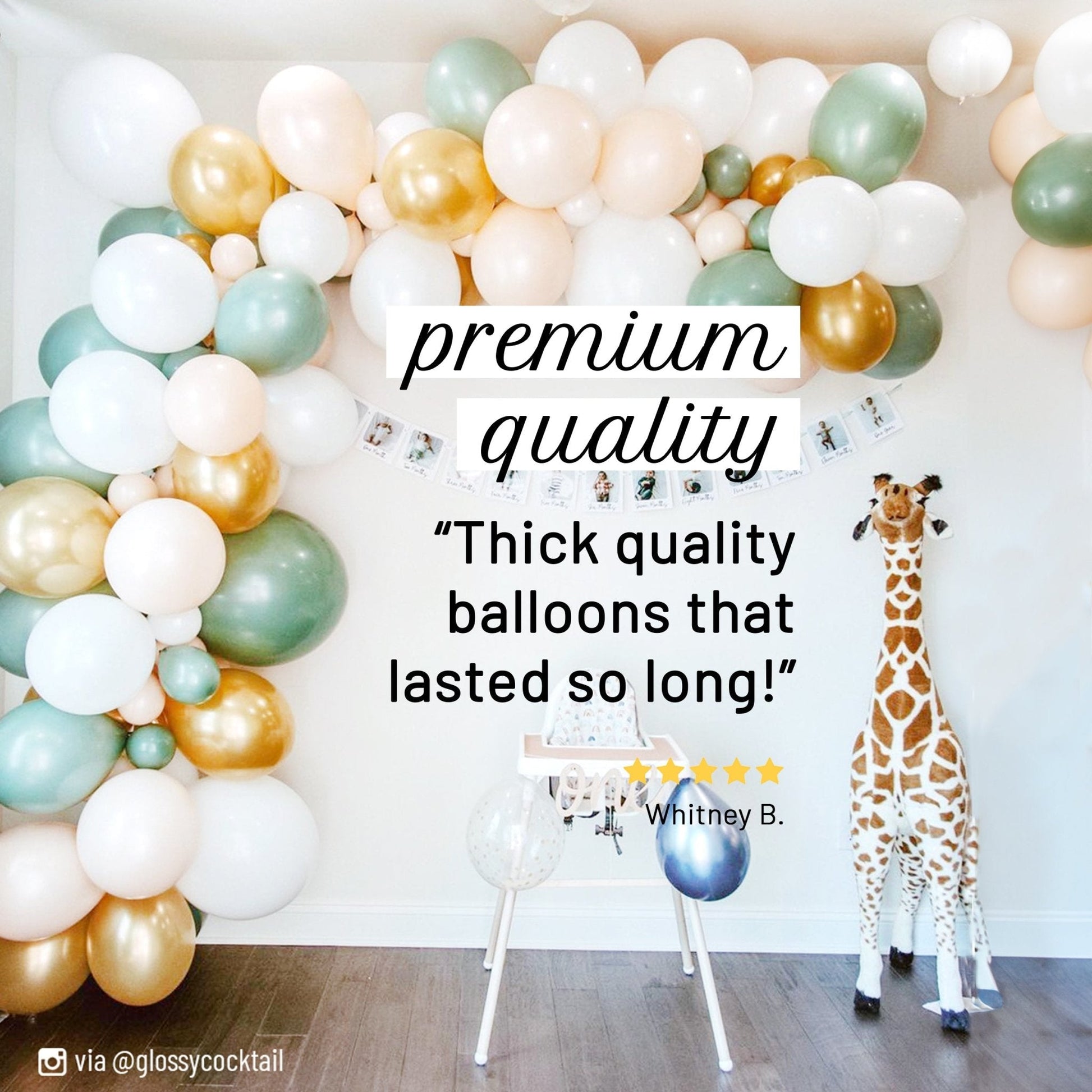 Balloon arch with colorful balloons and a giraffe toy in a room.