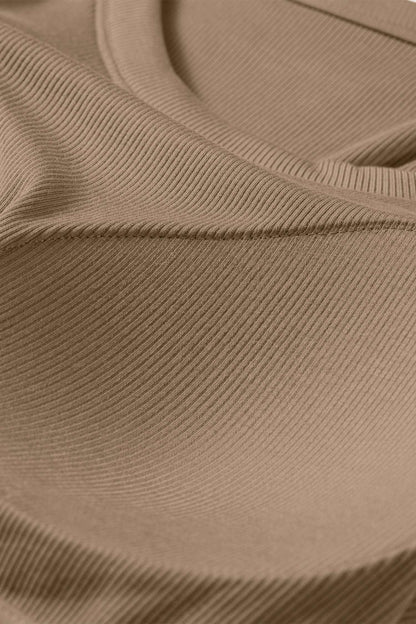 Close-up of a tan ribbed fabric tank top showing the textured material and curved seam of a padded bust.