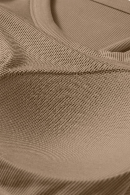 Close-up of a tan ribbed fabric tank top showing the textured material and curved seam of a padded bust.