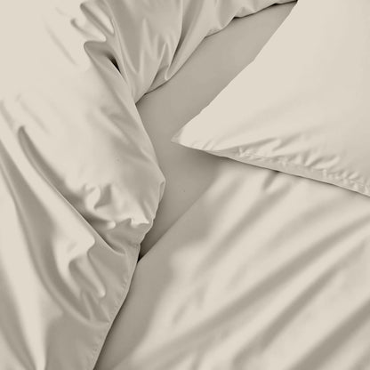Beige bedding set with pillows on a bed