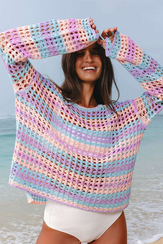 Pink, blue, and orange multi stripe open knit crochet sweater beach cover up worn by a woman at the beach.