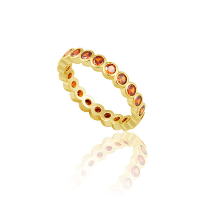 Gold ring with embedded red gemstones on a white background