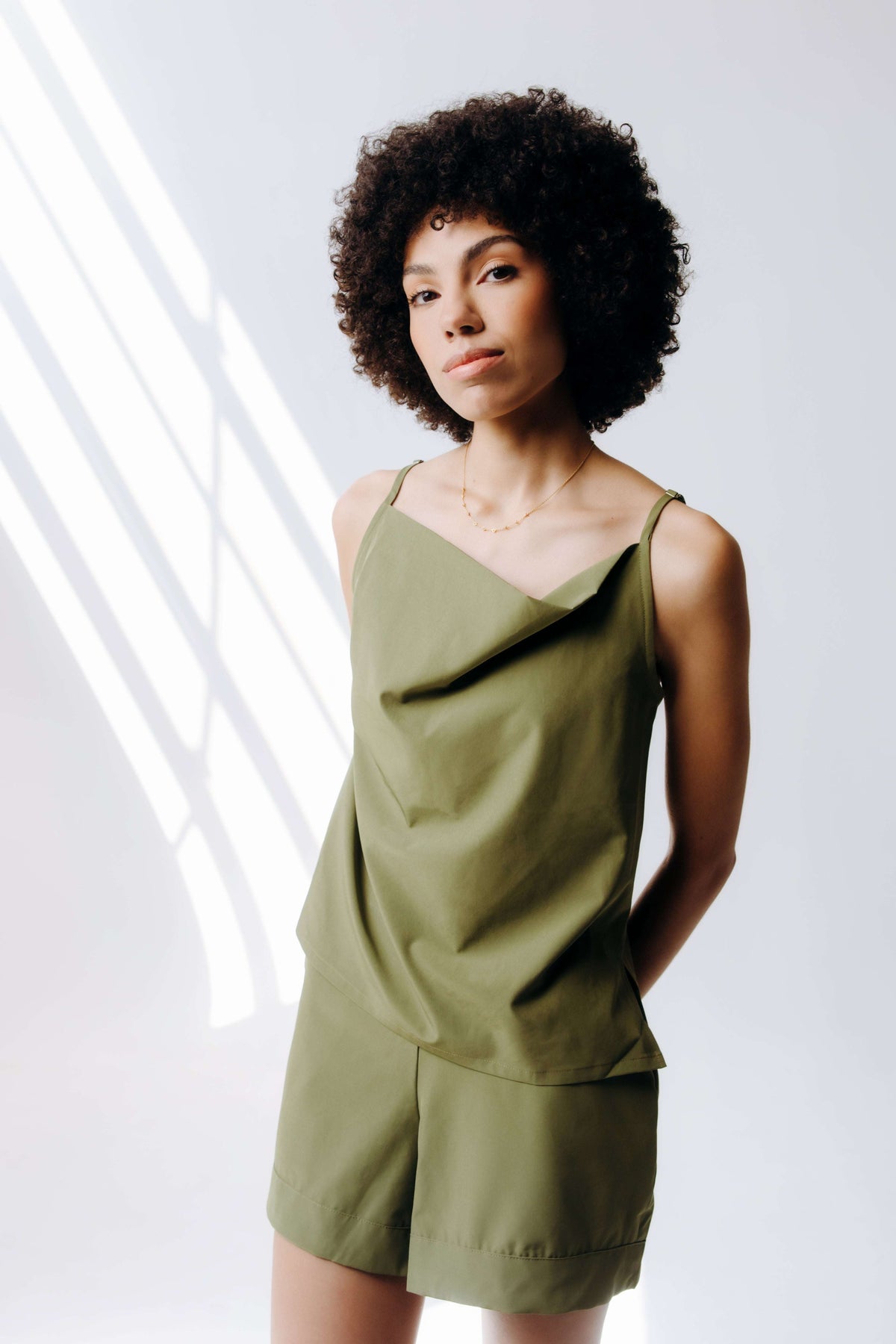 Woman wearing a green outfit against a white background