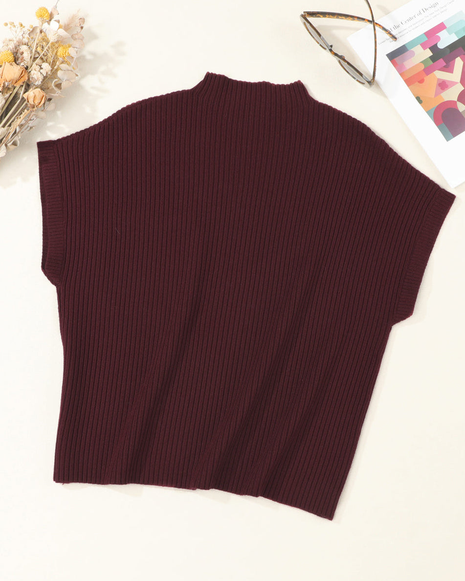 Brown ribbed sleeveless sweater on a white surface with decorative elements.