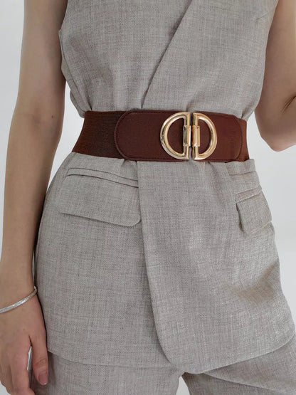 Person wearing a gray outfit with a brown belt and gold buckle on a white background