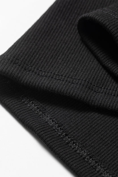 Close-up of a black ribbed knit fabric with visible stitching details.