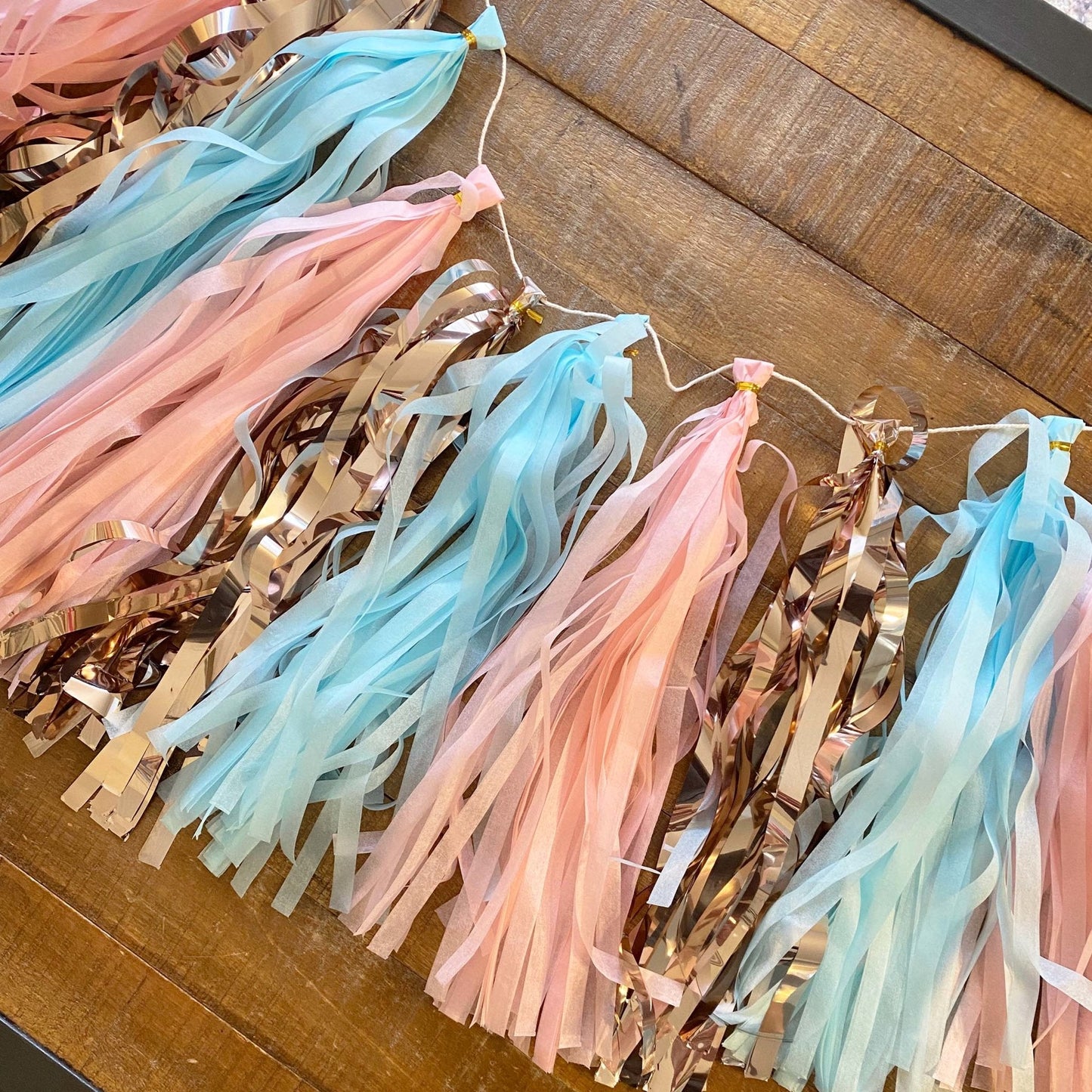 Decorative tassel garland with pastel colors on a wooden surface