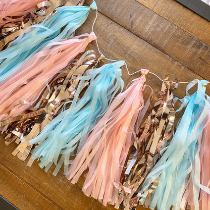 Decorative tassel garland with pastel colors on a wooden surface