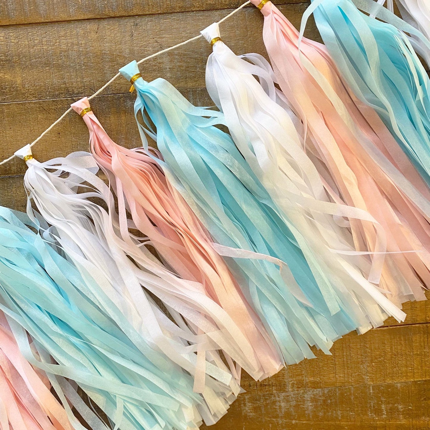 Pastel-colored tassel garland on a wooden surface