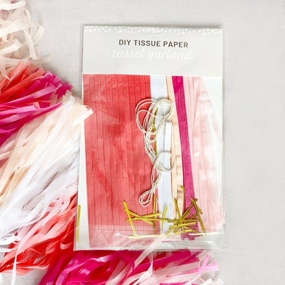 Packaging of DIY tissue paper with colorful strips and gold ribbons on a white background