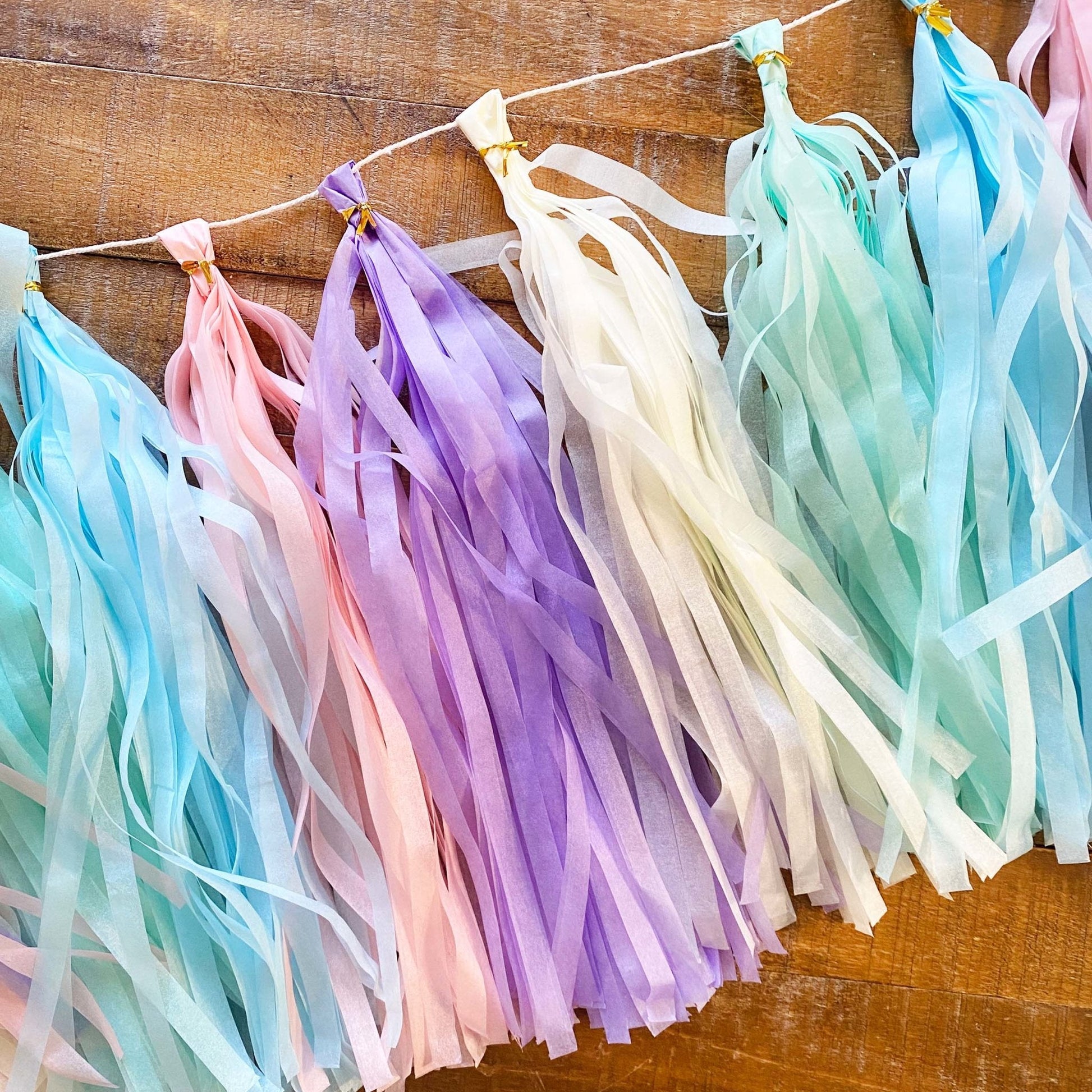 Pastel-colored tassel garland on a wooden surface