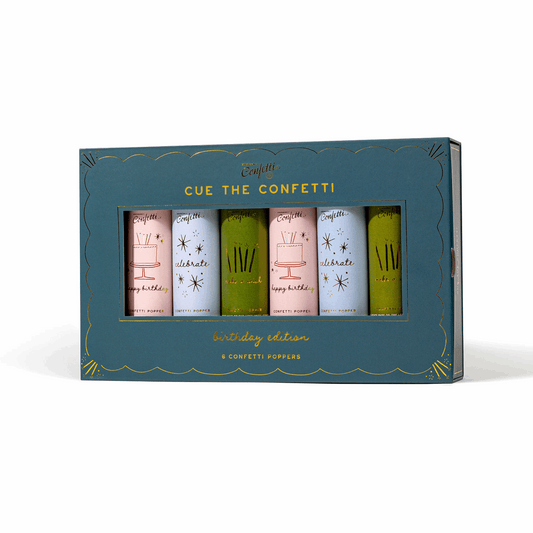 Six colorful paper confetti poppers in a teal Cue the Confetti Birthday Edition box with gold foil cake illustrations.