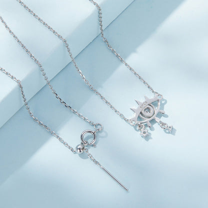 Back view of two silver necklaces with charms on a light blue background