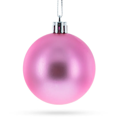 Single round pink plastic Christmas ornament with a matte finish and silver cap hanging from a string.