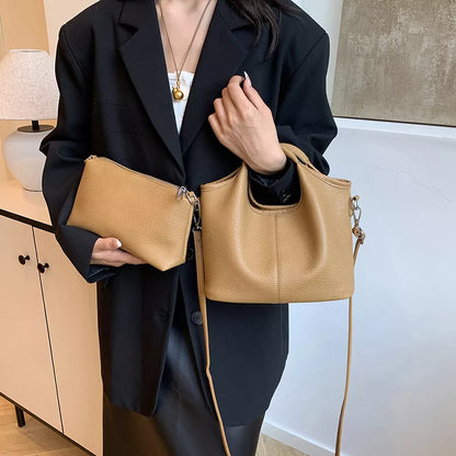 Person holding two beige handbags indoors