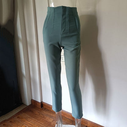 Teal pants on a mannequin against a neutral wall.