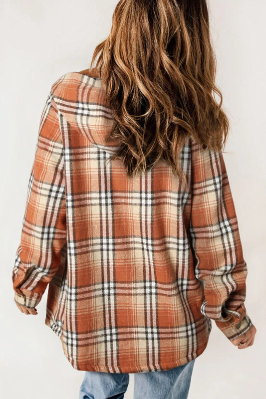 Person wearing a plaid shirt with a neutral background
