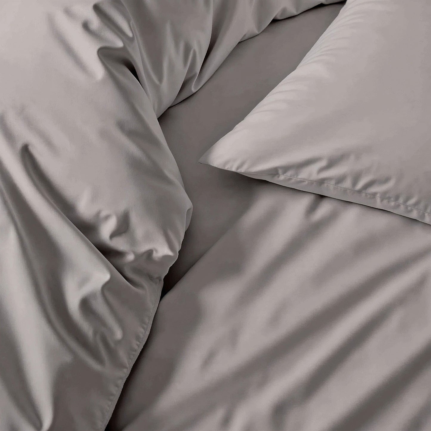 Gray bedding set with pillows on a bed