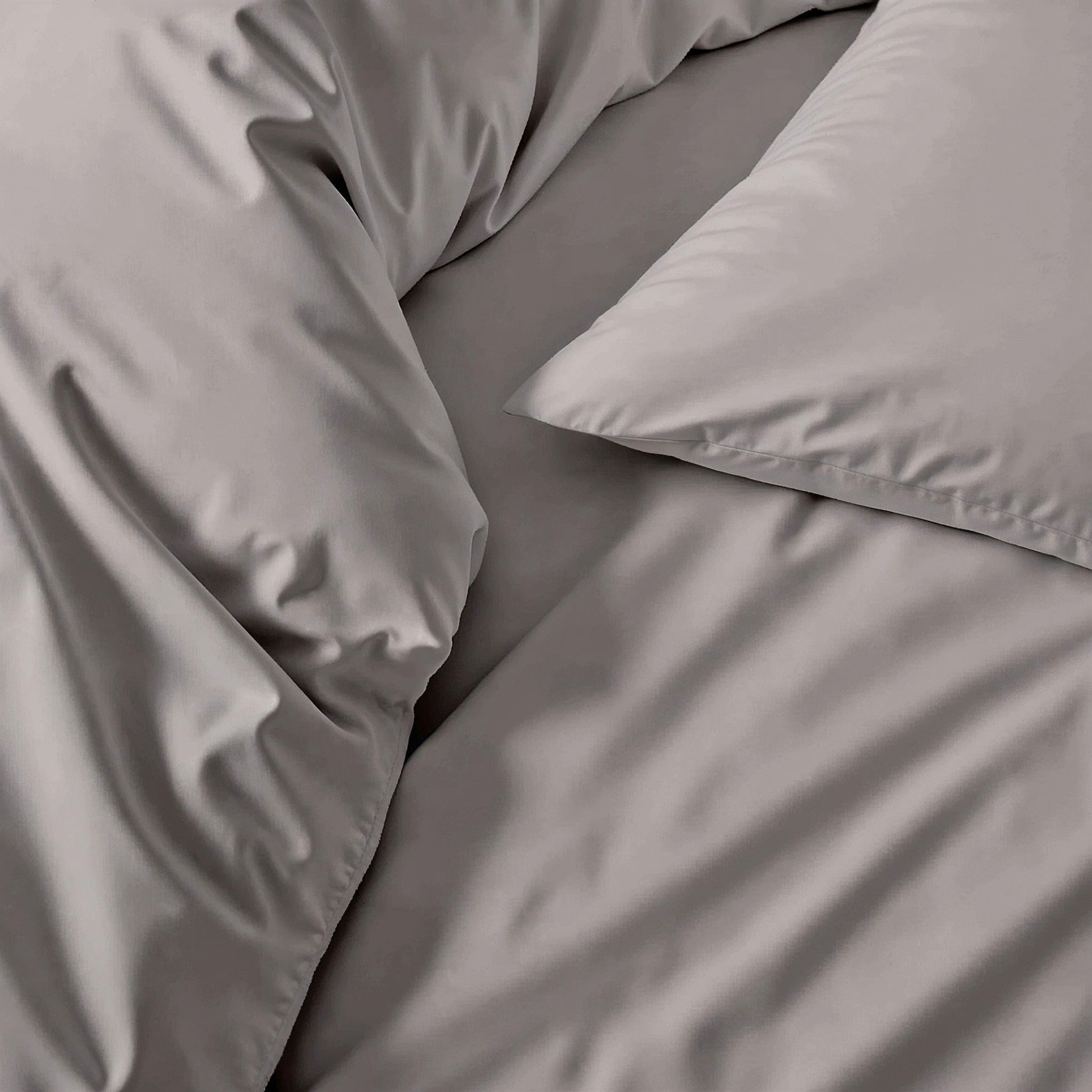Gray bedding set with pillows on a bed