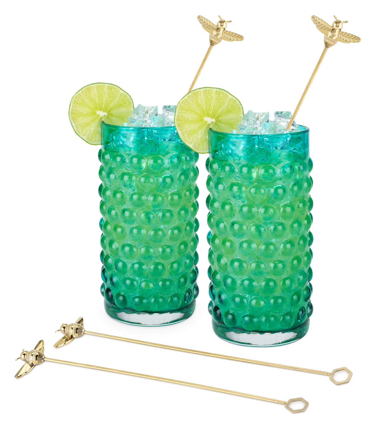 Gold bumble bee cocktail stirrers in two green glasses filled with ice and garnished with lime.