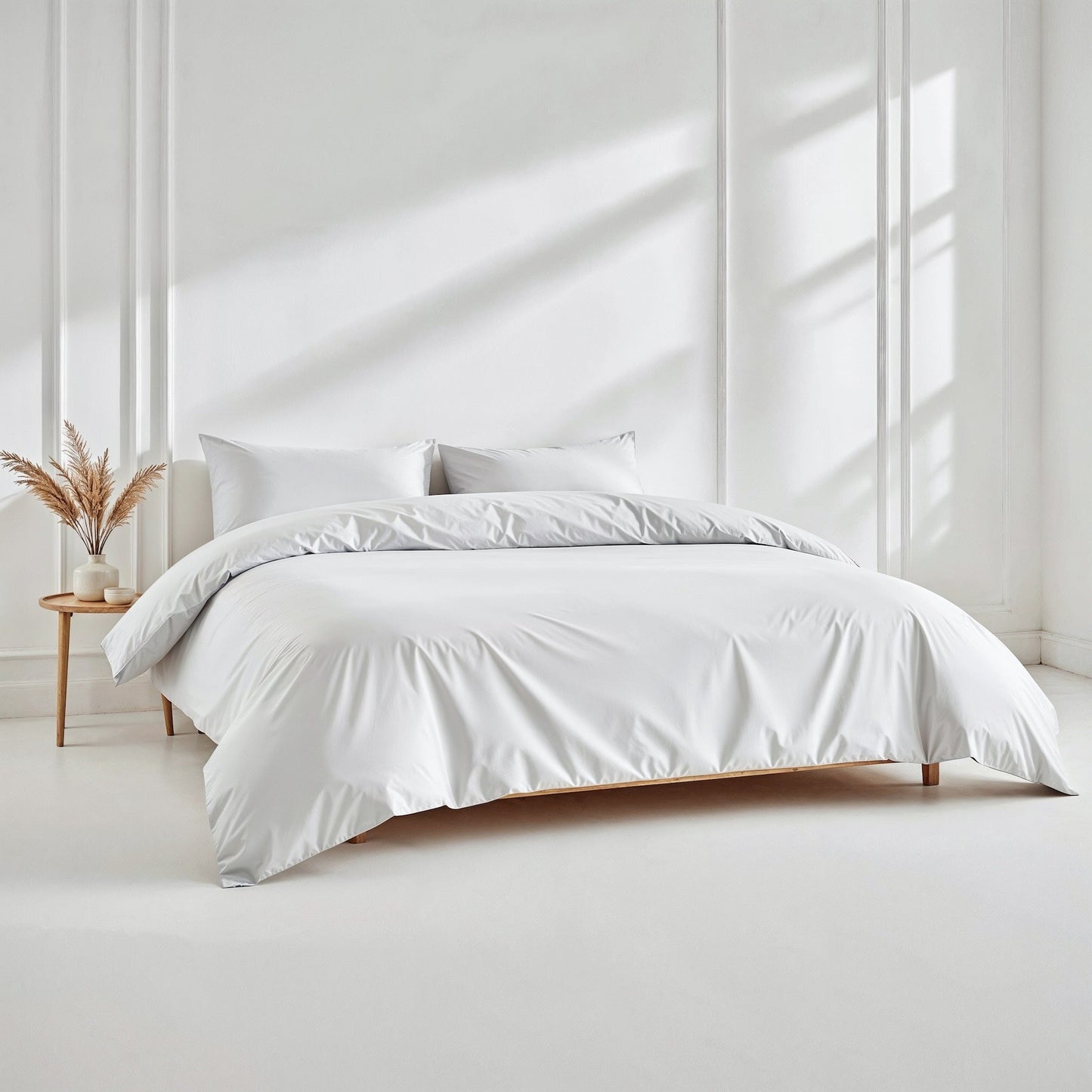 White bedding set on a bed in a bright room with minimal decor