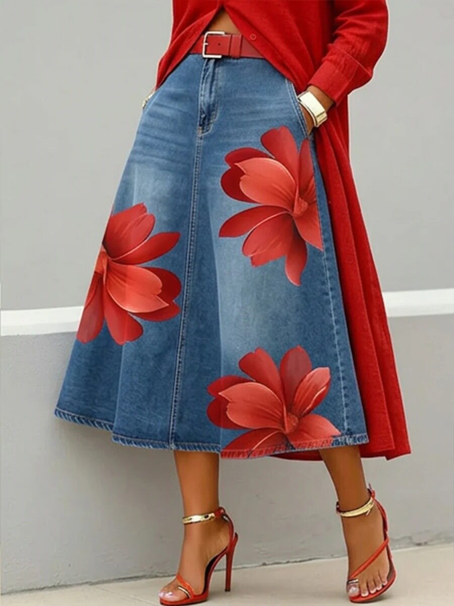 Person wearing a red floral denim skirt with a red coat against a gray background