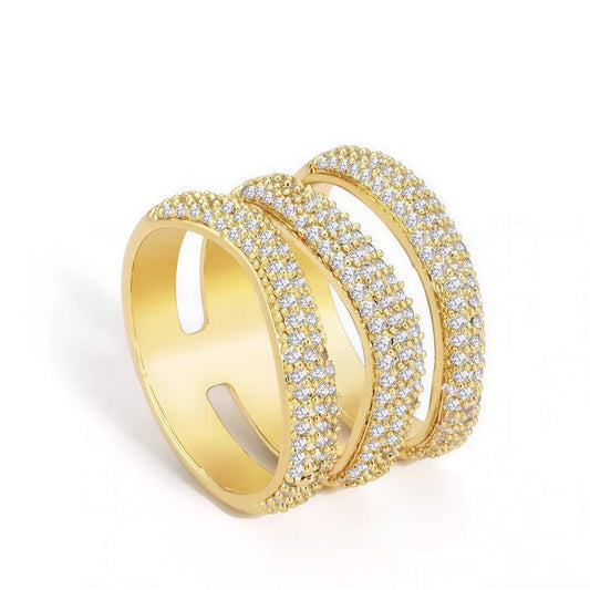Gold metal Elle Pave Ring featuring three parallel bands encrusted with small clear crystals on a white background.