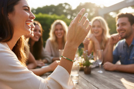 Gold bracelet with green and white gemstones on a white background
