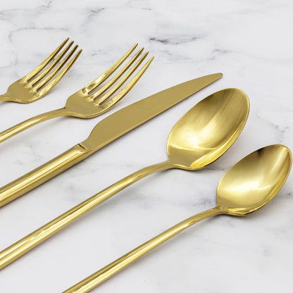 Set of gold cutlery including spoons and forks on a marble surface