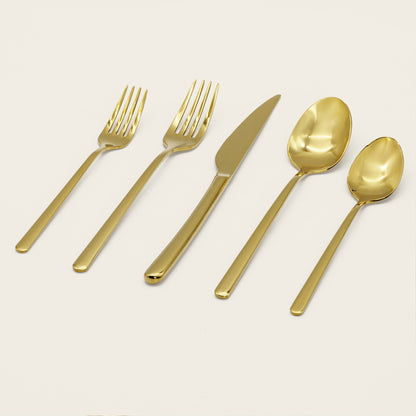 Set of gold flatware including forks, a knife, and spoons on a light background