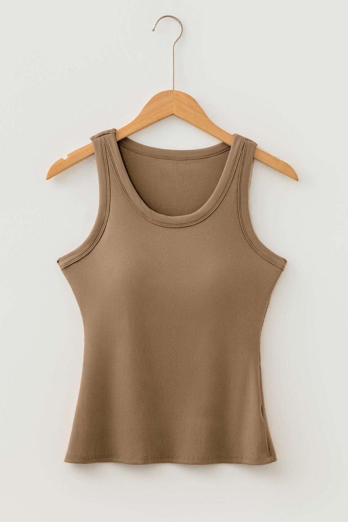 Brown ribbed fabric tank top with a scoop neck hanging on a light wood hanger against a white wall.