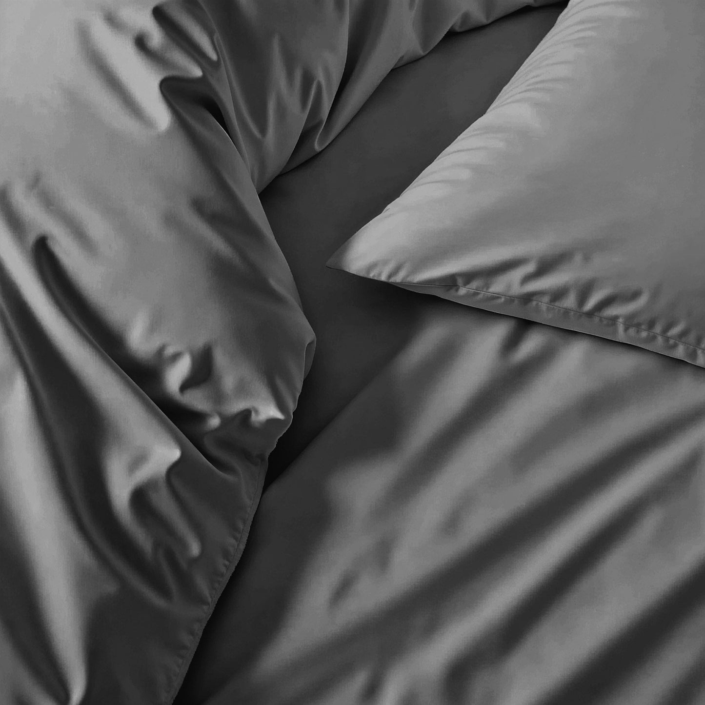 Gray bedding set with pillows on a bed