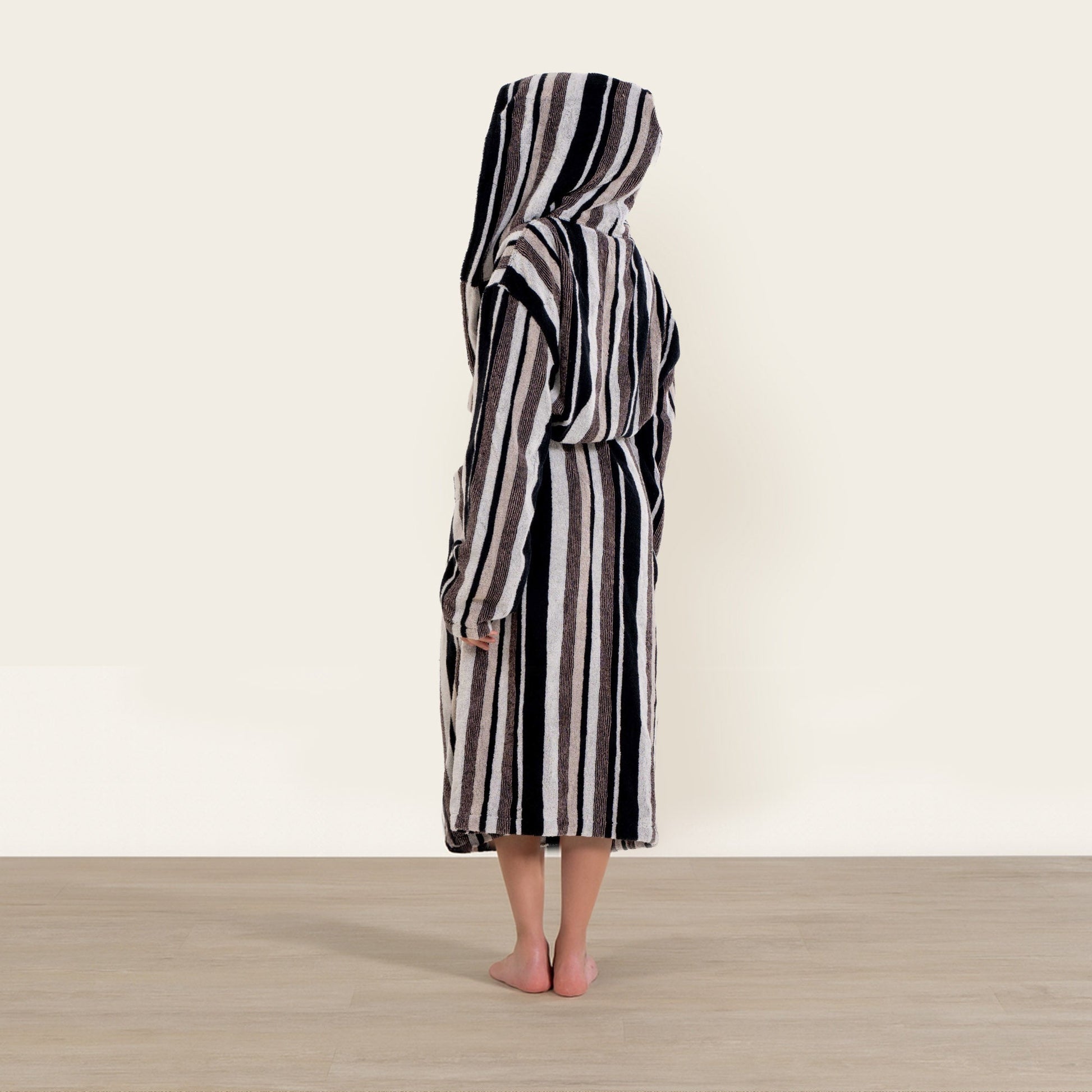 Person wearing a black and white striped robe on a plain background