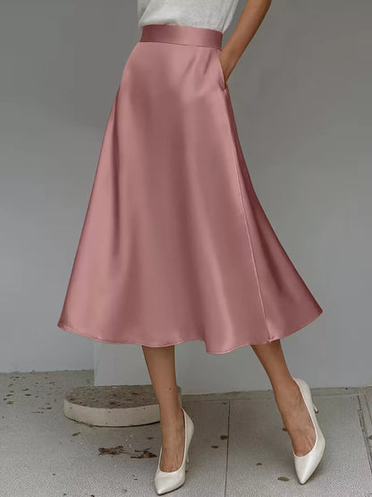 Pink satin skirt worn by a person on a plain background