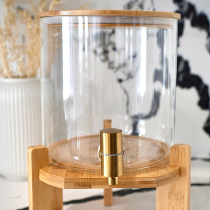 Glass container with wooden base and lid on a blurred background