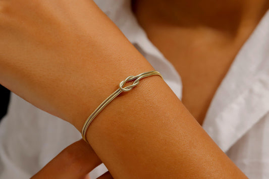 Gold bracelet on a person's wrist with a blurred background