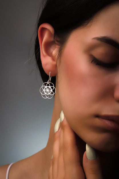 Dangle sacred geometry earrings in 925 sterling silver worn by a model, showcasing intricate design and shine.