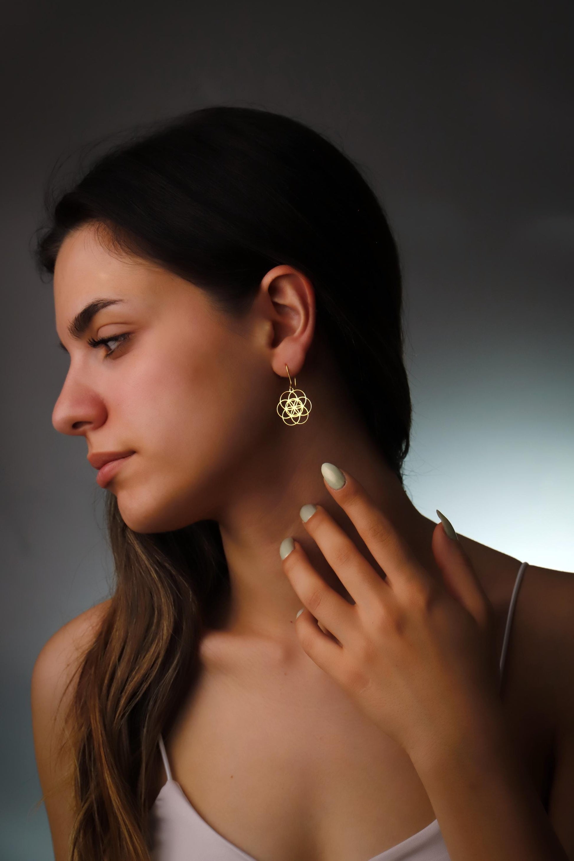 Dangle sacred geometry earrings in 925 sterling silver worn by a model, showcasing intricate design and elegant style.