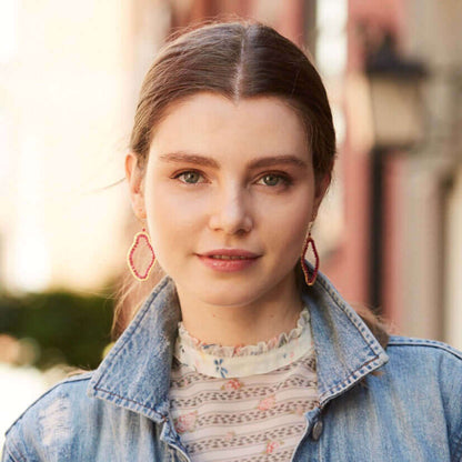Woman wearing a denim jacket with a blurred outdoor background