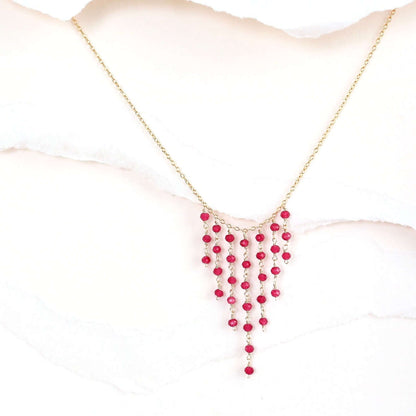 Necklace with red beads on a mannequin bust against a white background
